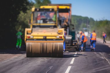 Asfaltlama ve asfalt kaldırım, asfalt kaldırım makinesi ve yol yapımı ve onarım çalışmaları sırasında buharlı yol silindiri, yeni yol inşaatında çalışan işçiler, yazın katman yerleştirme