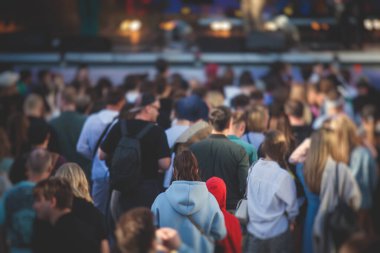 Sahne ışıklarıyla dolu kalabalık bir konser salonu, canlı gösteri performansı, insanların silueti, bir konser sırasında dans pisti.