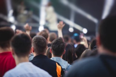 Sahne ışıklarıyla dolu kalabalık bir konser salonu, canlı gösteri performansı, insanların silueti, bir konser sırasında dans pisti.