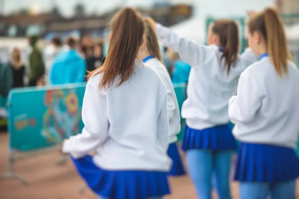 Kobieca Grupa Cheerleaderek Akcji Ubrana Biały Niebieski Mundur Publicznością Tle — Zdjęcie stockowe