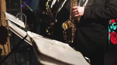 Sahnede caz orkestrası çalarken saksafoncu, saksafoncu, vokalist ve müzikalistin konser görüntüsü 