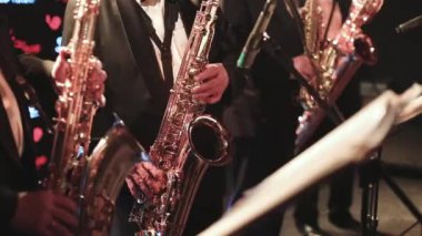 Sahnede caz orkestrası çalarken saksafoncu, saksafoncu, vokalist ve müzikalistin konser görüntüsü 
