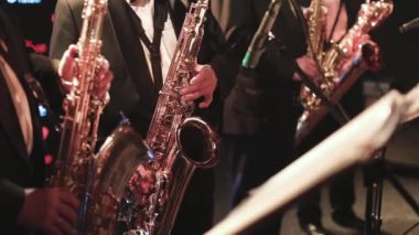 Sahnede caz orkestrası çalarken saksafoncu, saksafoncu, vokalist ve müzikalistin konser görüntüsü 