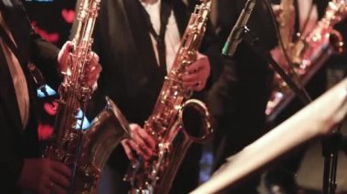 Sahnede caz orkestrası çalarken saksafoncu, saksafoncu, vokalist ve müzikalistin konser görüntüsü 