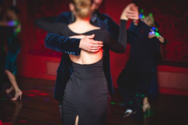 Balo salonunda geleneksel Latin dansı milongası yapan çiftler, kırmızı ve mor ışıklarda tango salsa bachata kizomba dersi, dans festivali