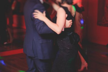Balo salonunda geleneksel Latin dansı milongası yapan çiftler, kırmızı ve mor ışıklarda tango salsa bachata kizomba dersi, dans festivali