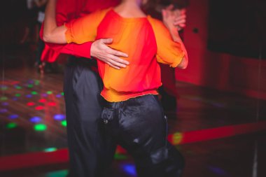 Balo salonunda geleneksel Latin dansı milongası yapan çiftler, kırmızı ve mor ışıklarda tango salsa bachata kizomba dersi, dans festivali