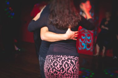 Balo salonunda geleneksel Latin dansı milongası yapan çiftler, kırmızı ve mor ışıklarda tango salsa bachata kizomba dersi, dans festivali