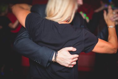 Balo salonunda geleneksel Latin dansı milongası yapan çiftler, kırmızı ve mor ışıklarda tango salsa bachata kizomba dersi, dans festivali