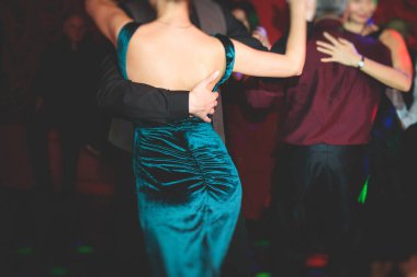Balo salonunda geleneksel Latin dansı milongası yapan çiftler, kırmızı ve mor ışıklarda tango salsa bachata kizomba dersi, dans festivali