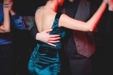 Balo salonunda geleneksel Latin dansı milongası yapan çiftler, kırmızı ve mor ışıklarda tango salsa bachata kizomba dersi, dans festivali