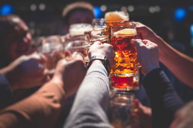 Bira festivali manzarası, bir barda altın renkli bira bardakları, filtresiz Alman buğday birası, insanların neşelenmesi ve hafif bira bardaklarıyla kadeh kaldırması, Oktoberfest manzarası