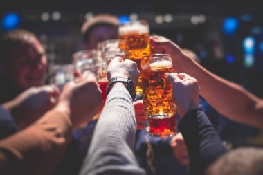 Bira festivali manzarası, bir barda altın renkli bira bardakları, filtresiz Alman buğday birası, insanların neşelenmesi ve hafif bira bardaklarıyla kadeh kaldırması, Oktoberfest manzarası