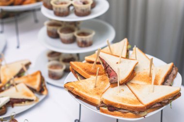 Konferans sırasında otelde kahve molası, çay ve kahve servisi, çeşitli hamur işleri, kruvasan ve kurabiyelerle süslenmiş ziyafet masası.