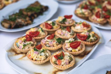 Yemek masası, çeşitli yiyeceklerle süslenmiş güzel bir ziyafet ve kurumsal doğum günü partisi etkinliği ya da Noel kutlaması için aperatifler, deniz ürünleri, kanepe, şarküteri.