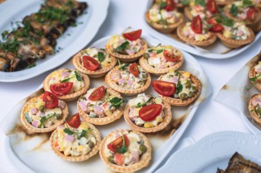 Yemek masası, çeşitli yiyeceklerle süslenmiş güzel bir ziyafet ve kurumsal doğum günü partisi etkinliği ya da Noel kutlaması için aperatifler, deniz ürünleri, kanepe, şarküteri.