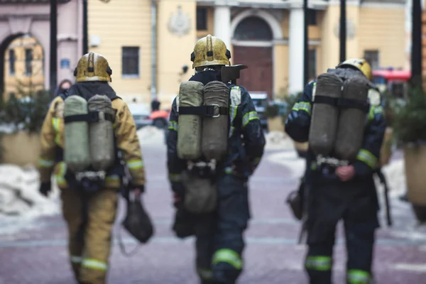 在城市街道消防行动中身穿制服的消防队员小组 以消防车为背景的消防队员 紧急救援人员 — 图库照片