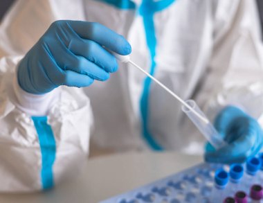 Laboratuvar laboratuarında hemşire doktor tarafından yapılan koronavirüs PCR antijen testi süreci, COVID-19 örnek toplama kiti, OP NP hasta numunesi almak için test tüpü, bir test örneği almak için hasta