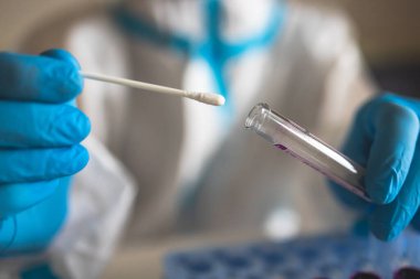 Laboratuvar laboratuarında hemşire doktor tarafından yapılan koronavirüs PCR antijen testi süreci, COVID-19 örnek toplama kiti, OP NP hasta numunesi almak için test tüpü, bir test örneği almak için hasta