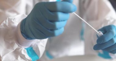 Laboratuvarda hemşire doktor tarafından yapılan koronavirüs PCR antijen testi süreci, COVID-19 pamuk toplama kiti, OP NP hasta numunesi almak için test tüpü, hastanın test edilmesi, dikey görüş.