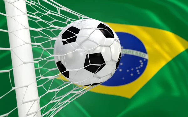 Brésil agitant drapeau et ballon de football dans le filet de but — Photo