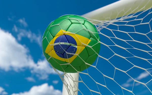 Brazil flag and soccer ball in goal net — Stock Photo, Image