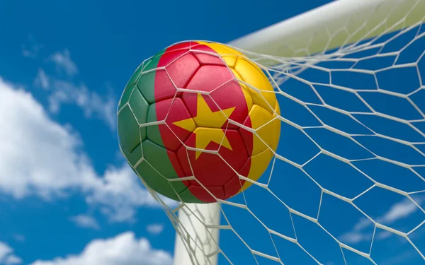 Cameroon flag and soccer ball in goal net — Stock Photo, Image