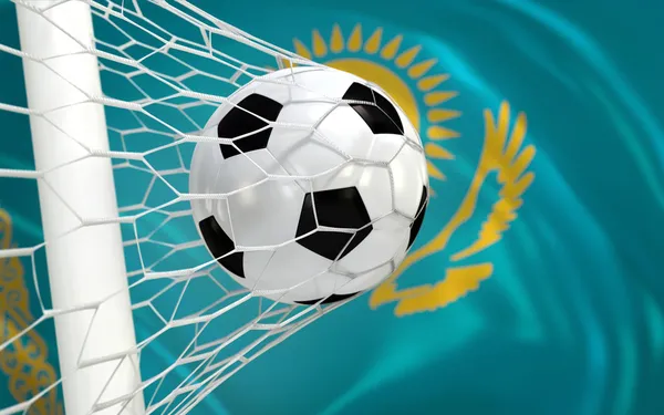 Vlag van Kazachstan en voetbal bal in doel netto — Stockfoto