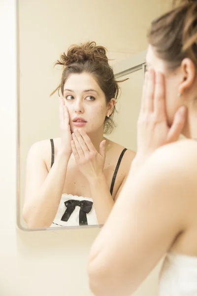 Jovem mulher olhando para si mesma no espelho — Fotografia de Stock