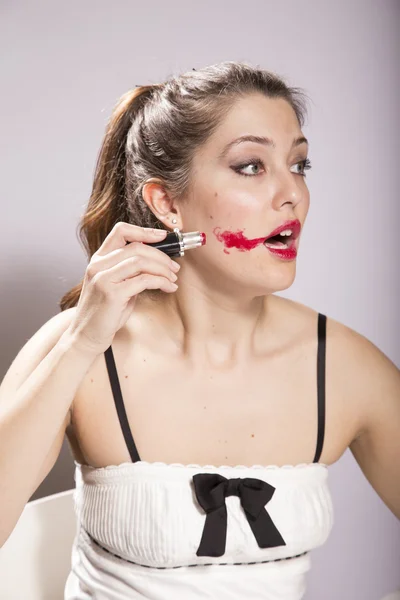 Young Woman Smearing Lipstick on her Face — Stock Photo, Image