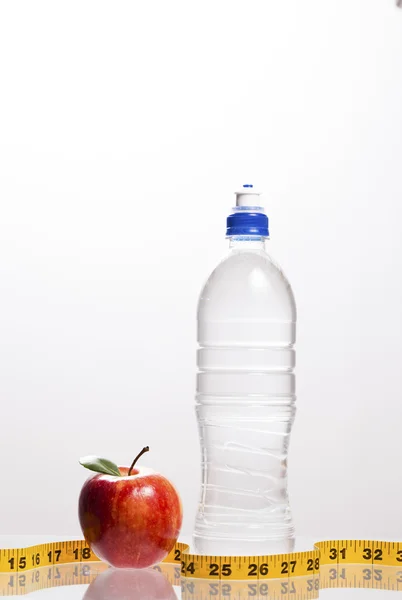 Roter Apfel und eine Flasche Wasser mit Maßband — Stockfoto