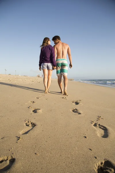 Mladý pár, chůze po pláži — Stock fotografie