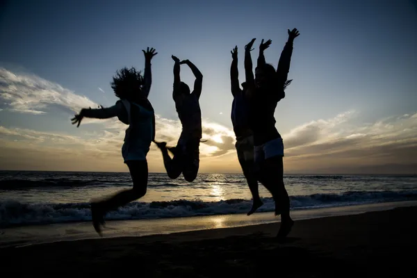 Dört Kişilik sahilde atlayarak Silhouettes