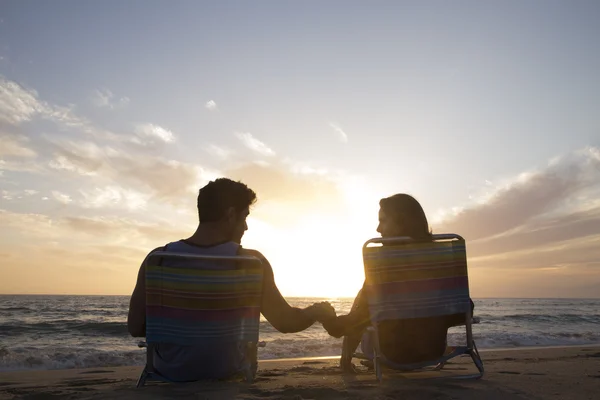 Junges Paar hält Händchen am Strand — Stockfoto