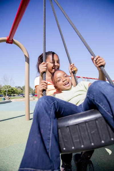 Dos chicas jóvenes divirtiéndose en un parque infantil —  Fotos de Stock