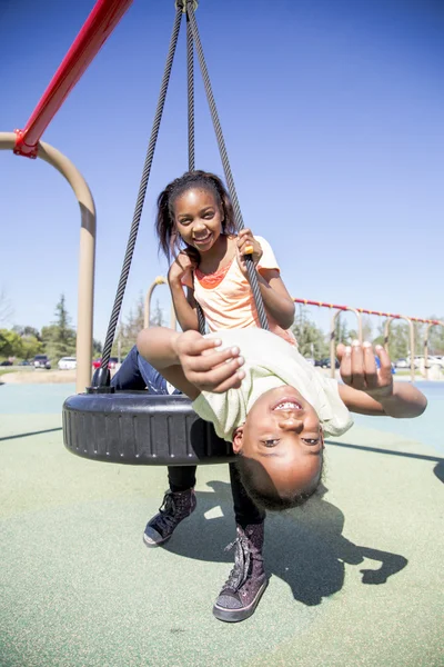 Dos chicas jóvenes divirtiéndose en un parque infantil —  Fotos de Stock