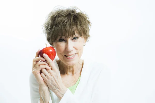 Zralá žena drží jablko — Stock fotografie