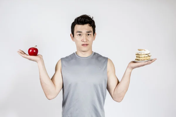 Junger Mann mit einem Apfel und einem Kuchen — Stockfoto