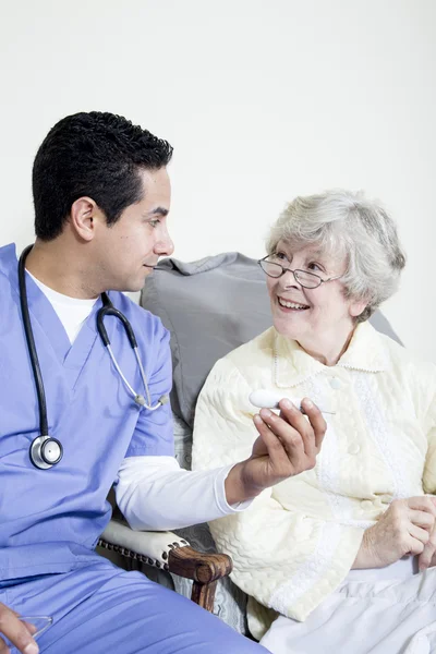 Enfermera asistiendo a un paciente anciano — Foto de Stock