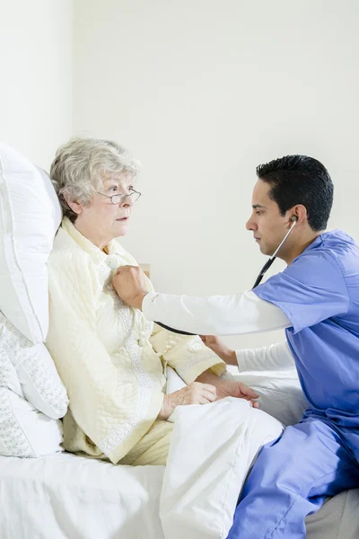 Enfermera masculina asistiendo a un paciente anciano — Foto de Stock