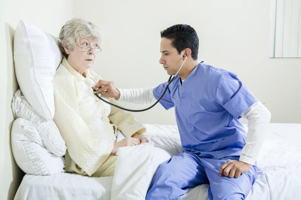 Enfermera masculina asistiendo a un paciente anciano — Foto de Stock