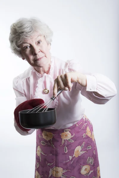 Anciana sosteniendo una olla y batido —  Fotos de Stock