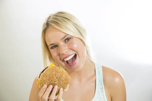 Jovem mulher comendo um hambúrguer — Fotografia de Stock