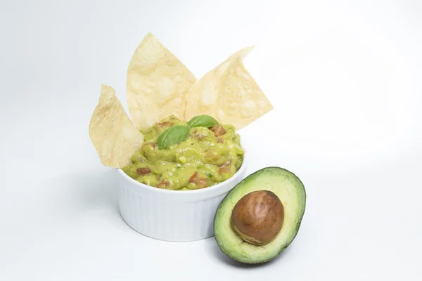 Tortilla-Chips, Guacamole & eine halbierte Avocado — Stockfoto