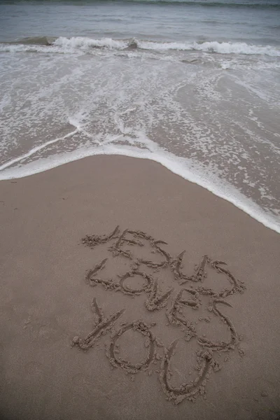 "예수 당신을 사랑합니다"모래에 기록 스톡 이미지