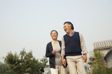 Senior couple walking outside in Beijing clipart