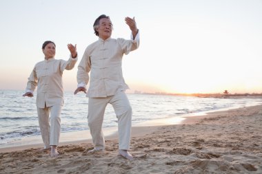 gün batımında sahilde taijiquan insanlar