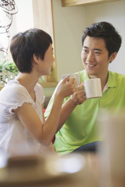 bir kafede otururken ve konuşurken iki arkadaş