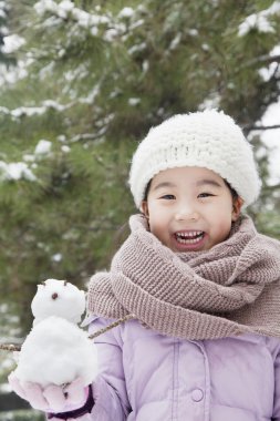 bir kardan adam parkta tutan kız