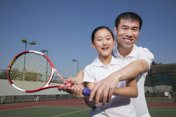 Ung flicka spela tennis med hennes tränare — Stockfoto